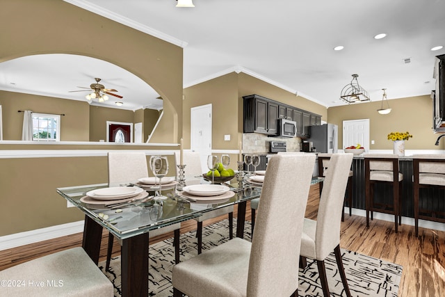 dining room featuring ceiling fan, crown molding, and wood-type flooring