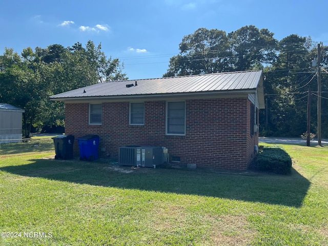 back of property featuring a lawn and central air condition unit