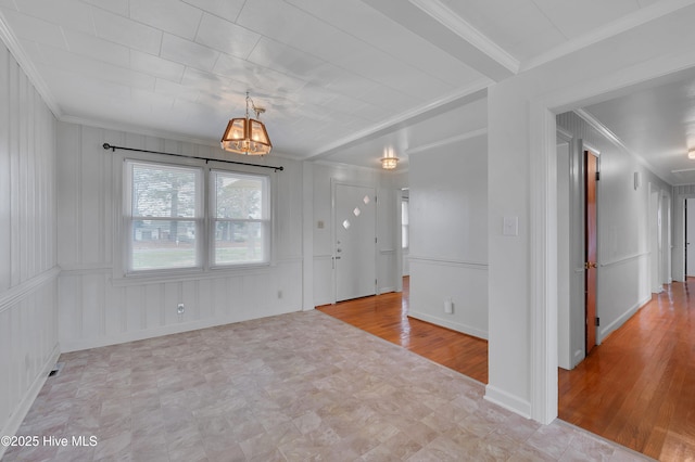 spare room featuring baseboards, ornamental molding, and wood finished floors