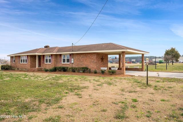 single story home with driveway, brick siding, and a front yard