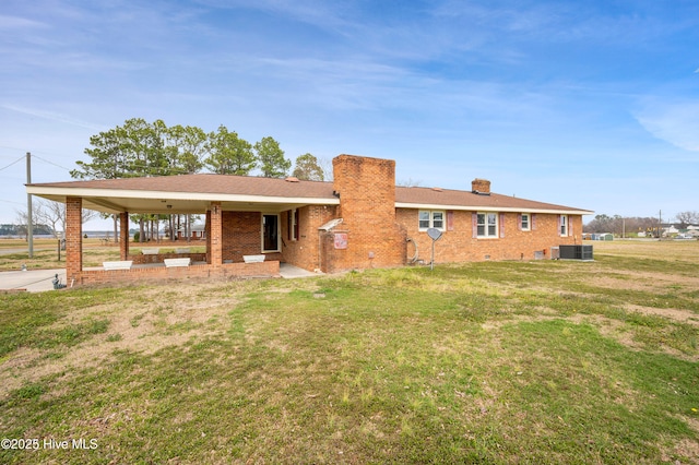 view of front of property featuring brick siding, a chimney, central air condition unit, crawl space, and a front lawn