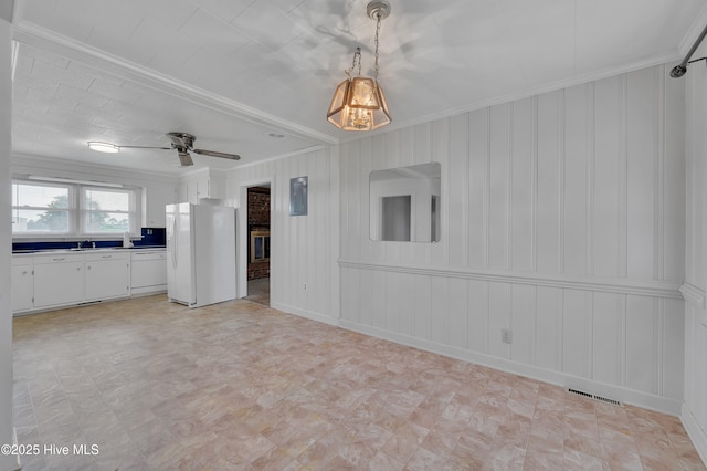 interior space featuring electric panel, visible vents, ceiling fan, crown molding, and a sink