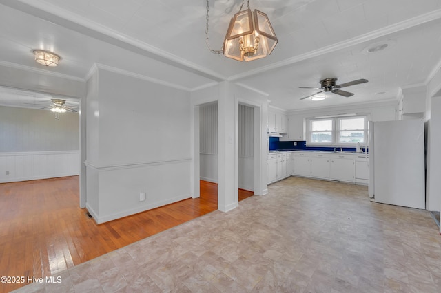 kitchen featuring ceiling fan, white cabinets, crown molding, and freestanding refrigerator