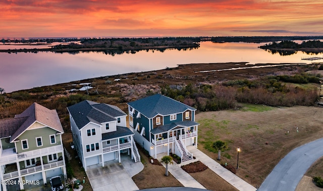 aerial view at dusk featuring a water view