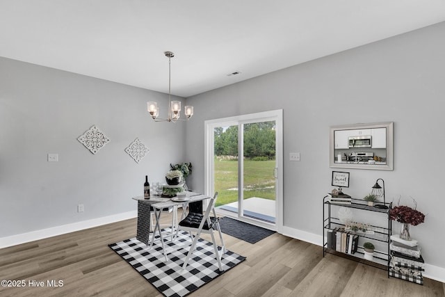 1399 Hammocks Beach Rd, Swansboro, NC 28584 - dining space with wood finished floors, a chandelier, baseboards, and an office area
