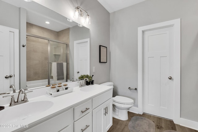 1399 Hammocks Beach Rd, Swansboro, NC 28584 - full bath with double vanity, toilet, wood finished floors, and shower / bath combination with glass door