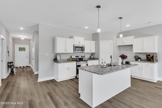 1399 Hammocks Beach Rd, Swansboro, NC 28584 - kitchen featuring stainless steel appliances, a sink, light wood-style flooring, recessed lighting, and light stone countertops