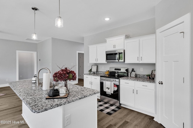1399 Hammocks Beach Rd, Swansboro, NC 28584 - kitchen featuring appliances with stainless steel finishes, a sink, light stone countertops, white cabinets, and light wood-style floors