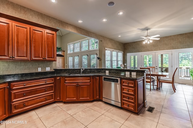 kitchen with dark stone countertops, a healthy amount of sunlight, sink, and stainless steel dishwasher