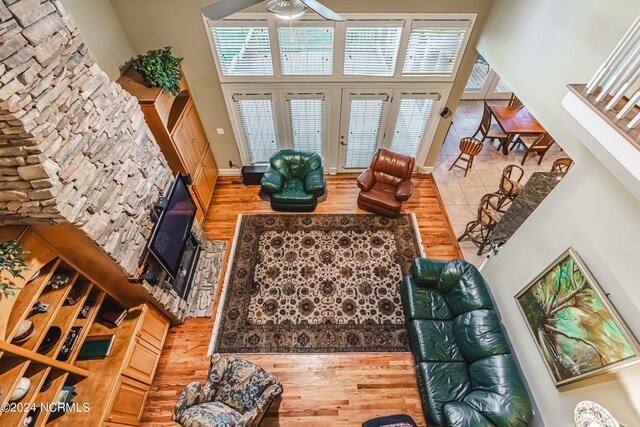 living room featuring ceiling fan, hardwood / wood-style flooring, and a high ceiling