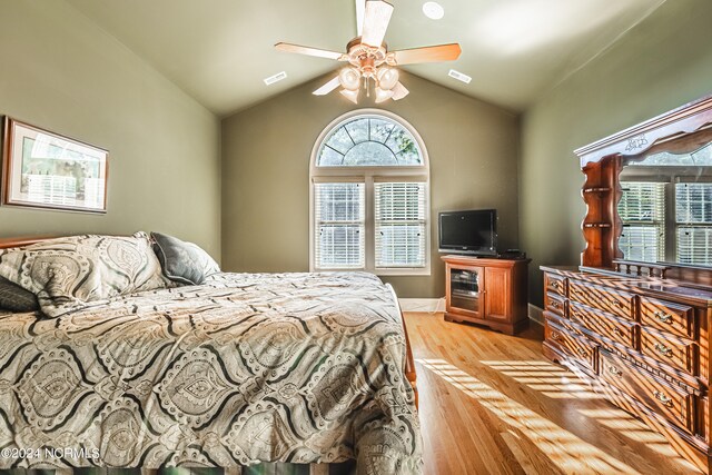 bedroom with light hardwood / wood-style floors, lofted ceiling, and ceiling fan