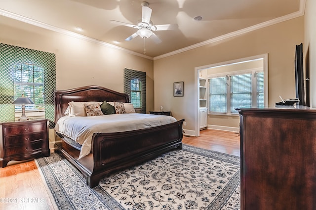 bedroom featuring crown molding, light hardwood / wood-style flooring, and ceiling fan