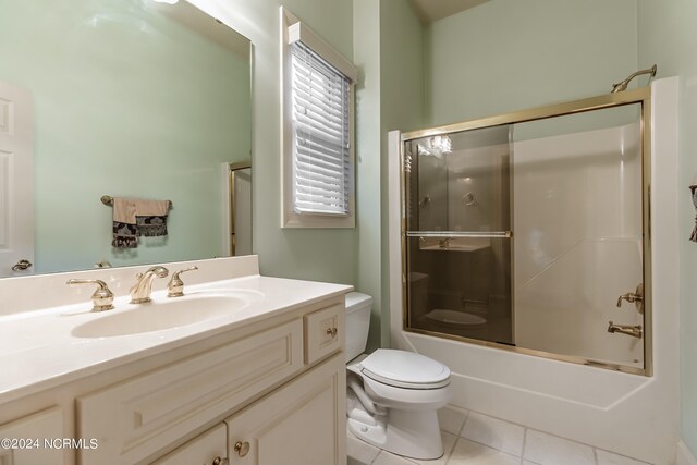 full bathroom with toilet, bath / shower combo with glass door, vanity, and tile patterned floors