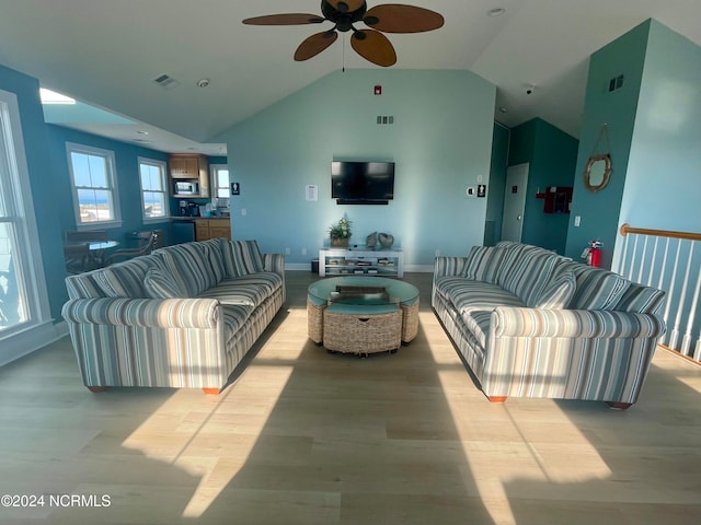 living room with light hardwood / wood-style floors, vaulted ceiling, and ceiling fan