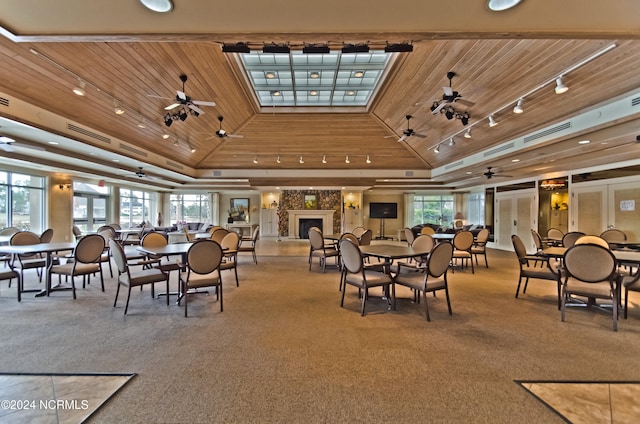 carpeted dining room with lofted ceiling, a healthy amount of sunlight, wooden ceiling, and ceiling fan