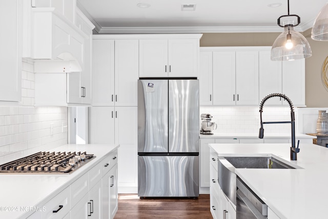 kitchen featuring tasteful backsplash, stainless steel appliances, white cabinetry, and hanging light fixtures