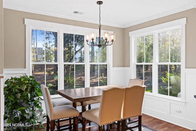 dining room with a chandelier, wood-type flooring, and crown molding