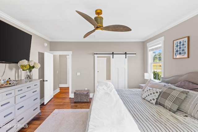 bedroom with ceiling fan, a barn door, ornamental molding, and dark hardwood / wood-style floors