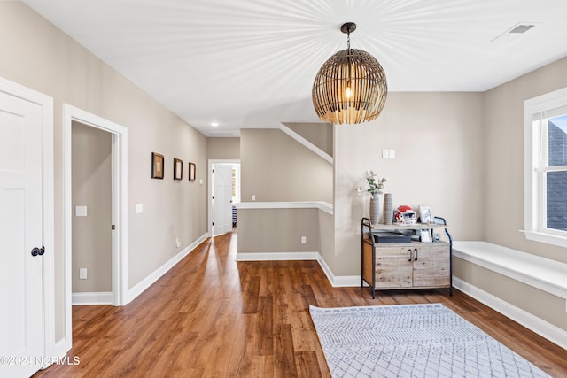 hall featuring a chandelier and wood-type flooring