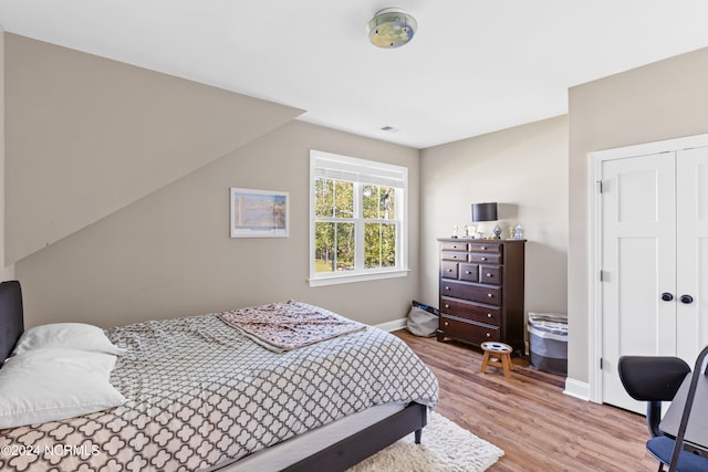 bedroom featuring wood-type flooring and vaulted ceiling