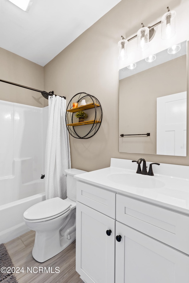 full bathroom with hardwood / wood-style floors, vanity, toilet, and shower / tub combo