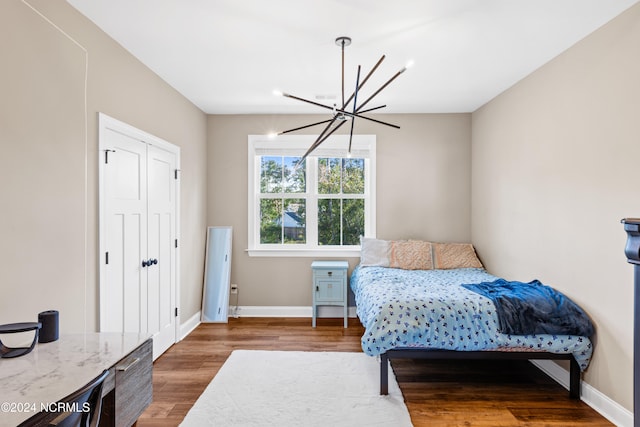 bedroom with dark wood-type flooring and a chandelier