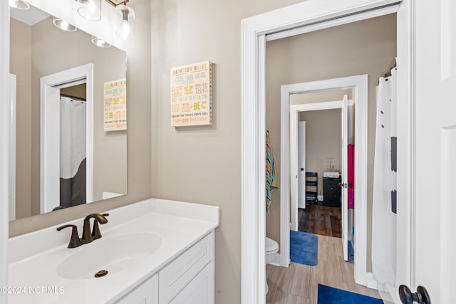 bathroom with vanity, wood-type flooring, and toilet