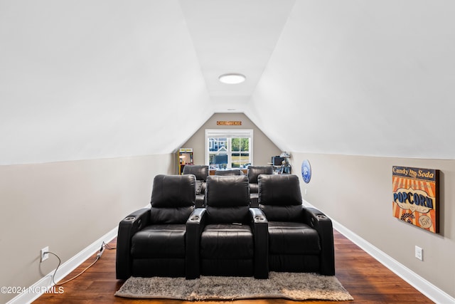 cinema room featuring dark hardwood / wood-style flooring and vaulted ceiling