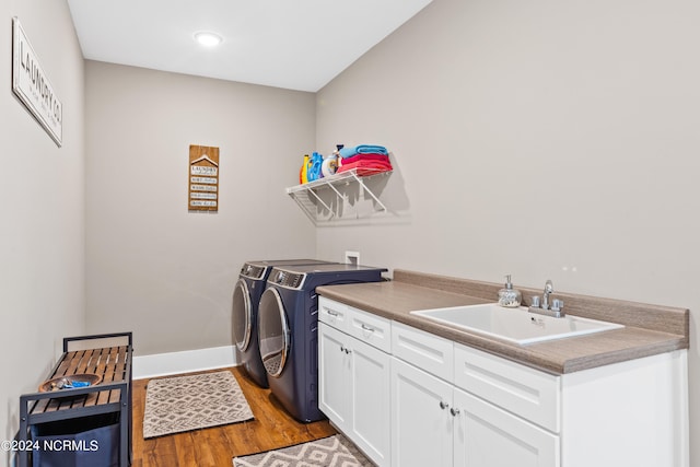 washroom featuring cabinets, washing machine and dryer, hardwood / wood-style flooring, and sink