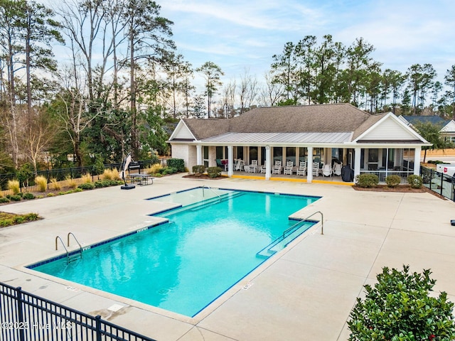 view of swimming pool featuring a sunroom and a patio area