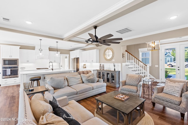 living room with ceiling fan with notable chandelier, dark hardwood / wood-style flooring, ornamental molding, and french doors