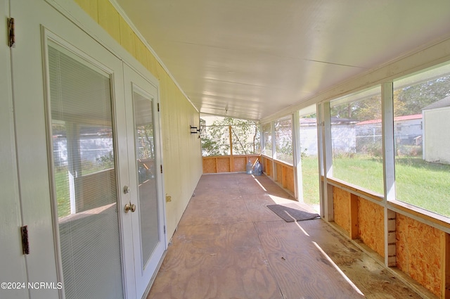 unfurnished sunroom featuring lofted ceiling and plenty of natural light