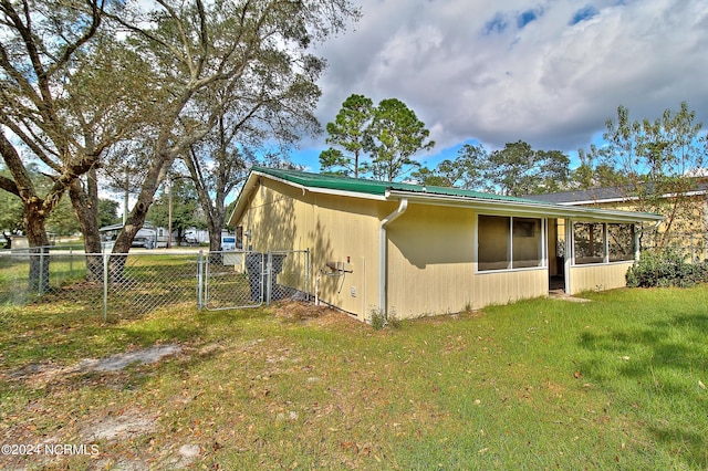 view of property exterior with a lawn and a sunroom