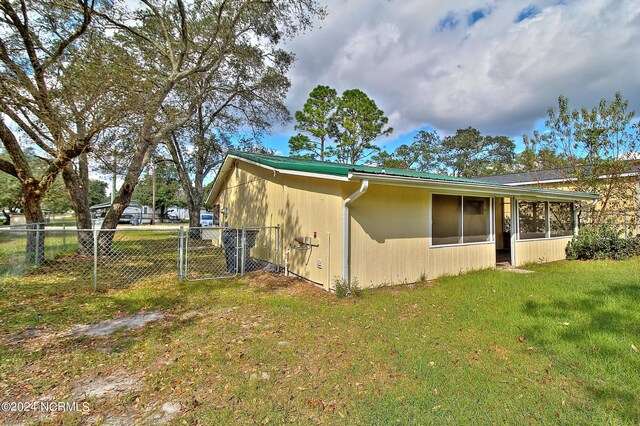 2989 Bird Dr SW, Shallotte, NC 28470 - view of property exterior with a sunroom, metal roof, and a gate