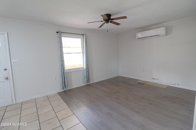 unfurnished room featuring ceiling fan, an AC wall unit, and light hardwood / wood-style flooring