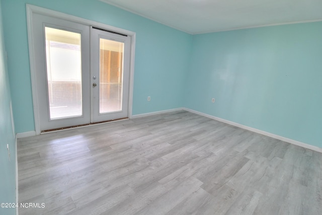 empty room featuring light hardwood / wood-style floors and french doors