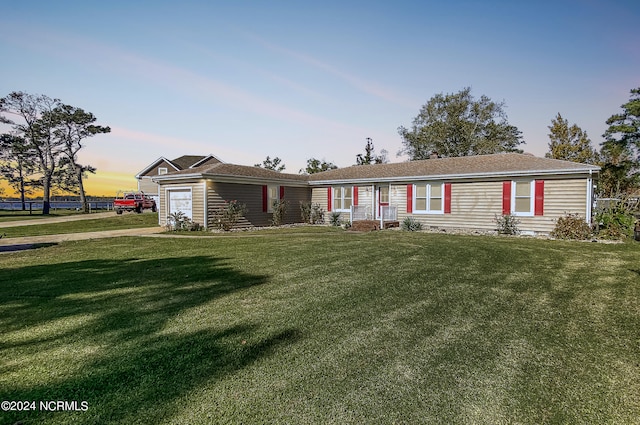 view of front of home featuring a garage and a lawn