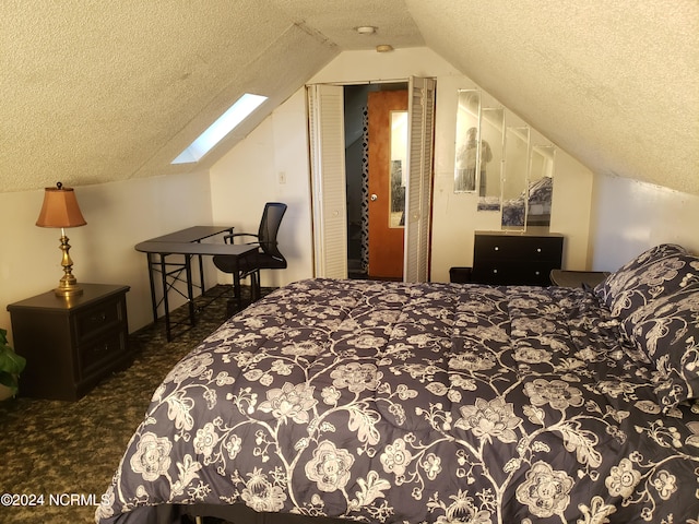 carpeted bedroom featuring lofted ceiling with skylight and a textured ceiling