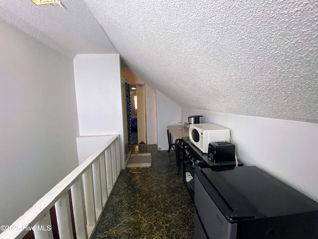 interior space featuring vaulted ceiling and a textured ceiling