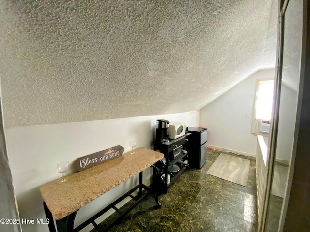 home office with lofted ceiling and a textured ceiling