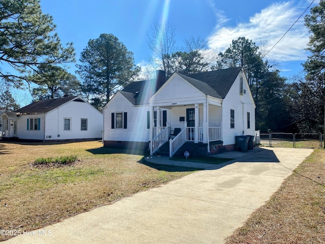 bungalow with a chimney, a porch, a front yard, a gate, and fence