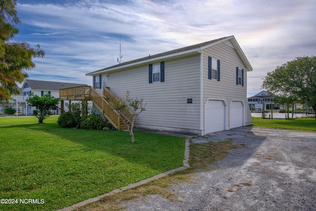 view of side of property featuring a garage, a lawn, and a deck