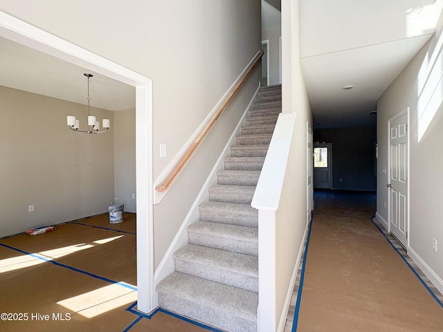 stairway featuring a notable chandelier