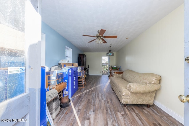 living area featuring hardwood / wood-style floors and ceiling fan