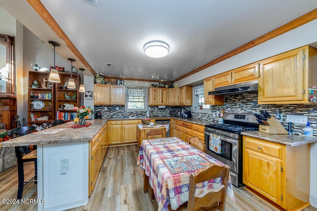 kitchen featuring decorative backsplash, a breakfast bar area, light hardwood / wood-style flooring, stainless steel gas range, and pendant lighting