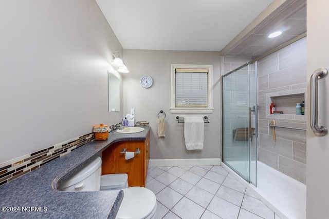 bathroom with tasteful backsplash, toilet, walk in shower, vanity, and tile patterned flooring