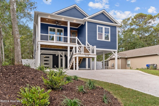 view of front of house featuring ceiling fan, a front lawn, covered porch, and a carport