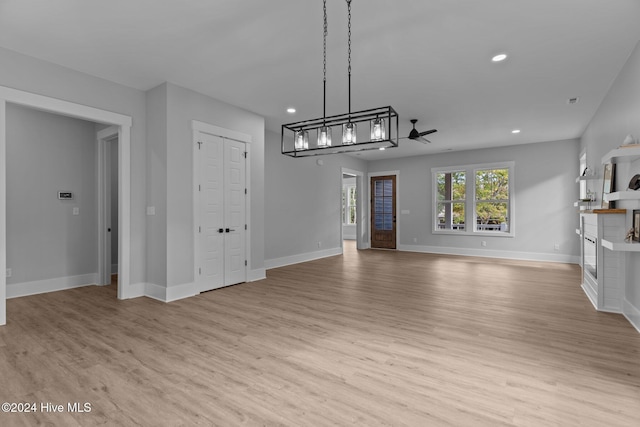 unfurnished living room with light wood-type flooring and ceiling fan