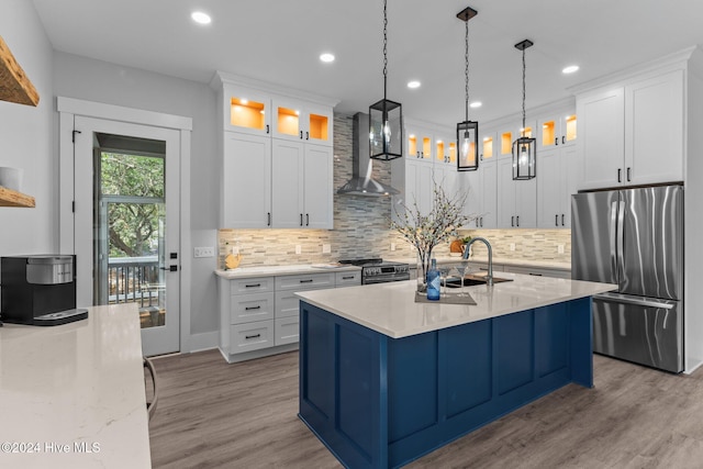 kitchen with appliances with stainless steel finishes, light stone counters, wall chimney exhaust hood, pendant lighting, and white cabinetry