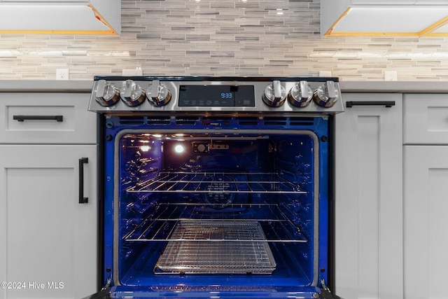 details with white cabinets and electric stove